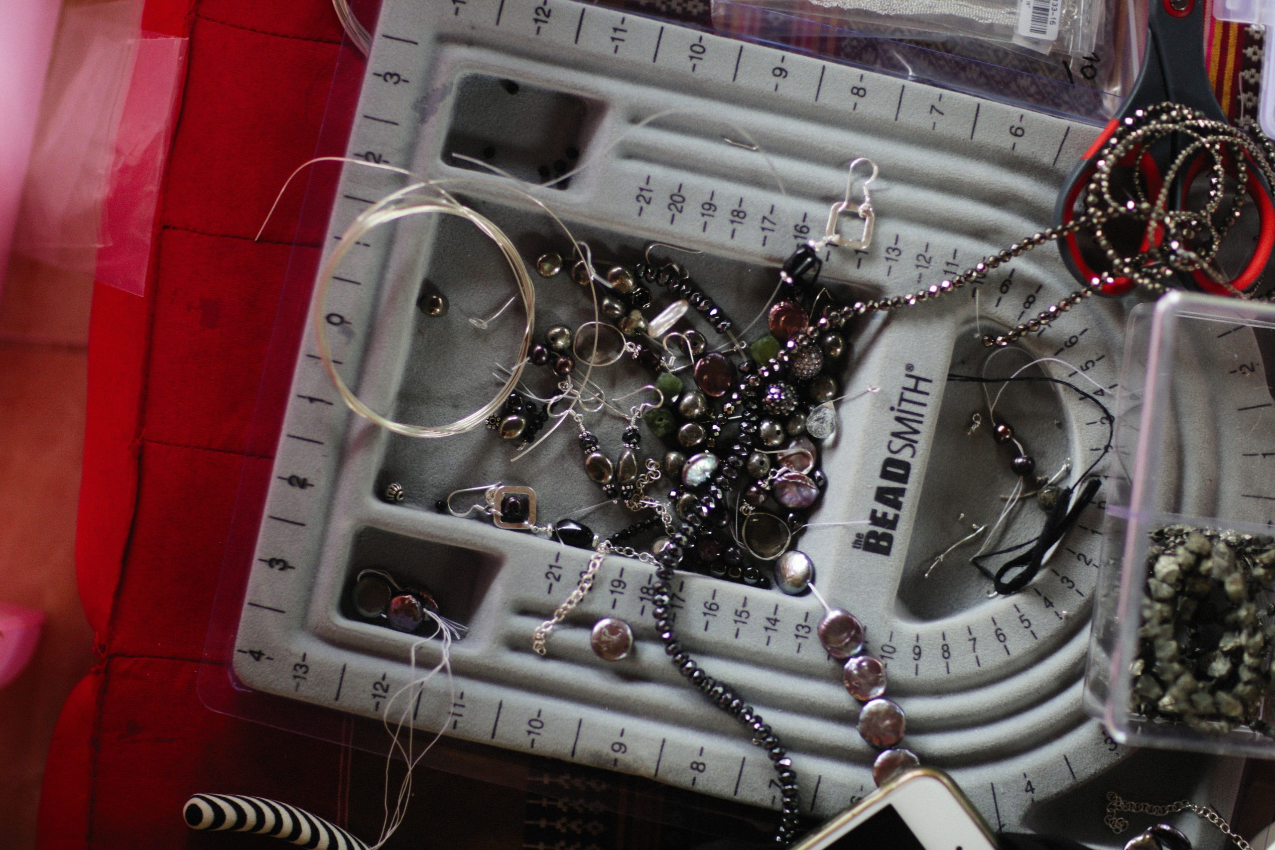 Espace de travail joaillerie avec outils perles.