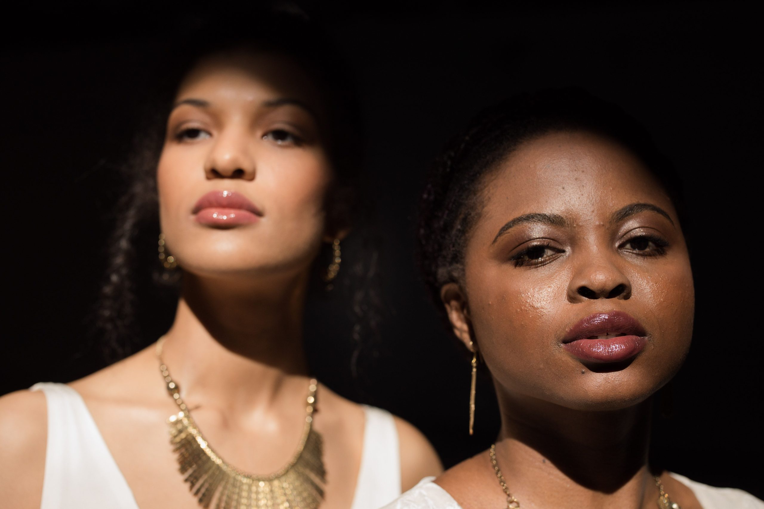 Deux femmes avec bijoux or fond noir