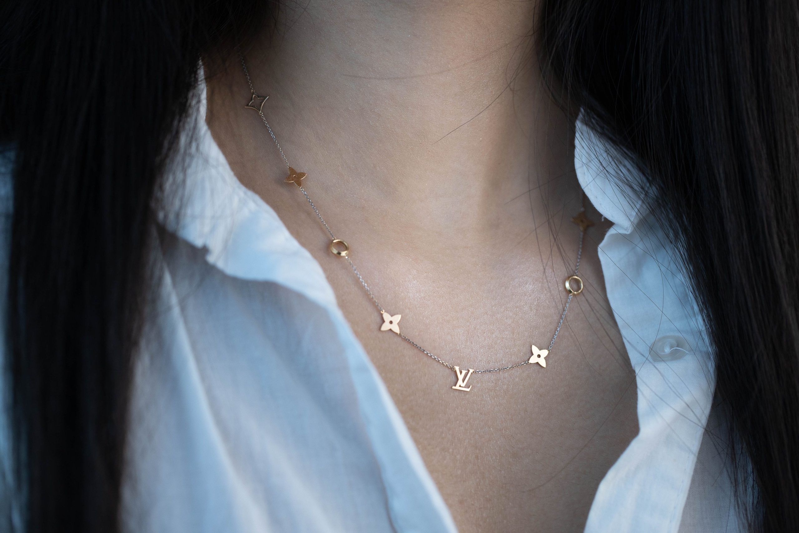 Collier or porté chemise blanche chic