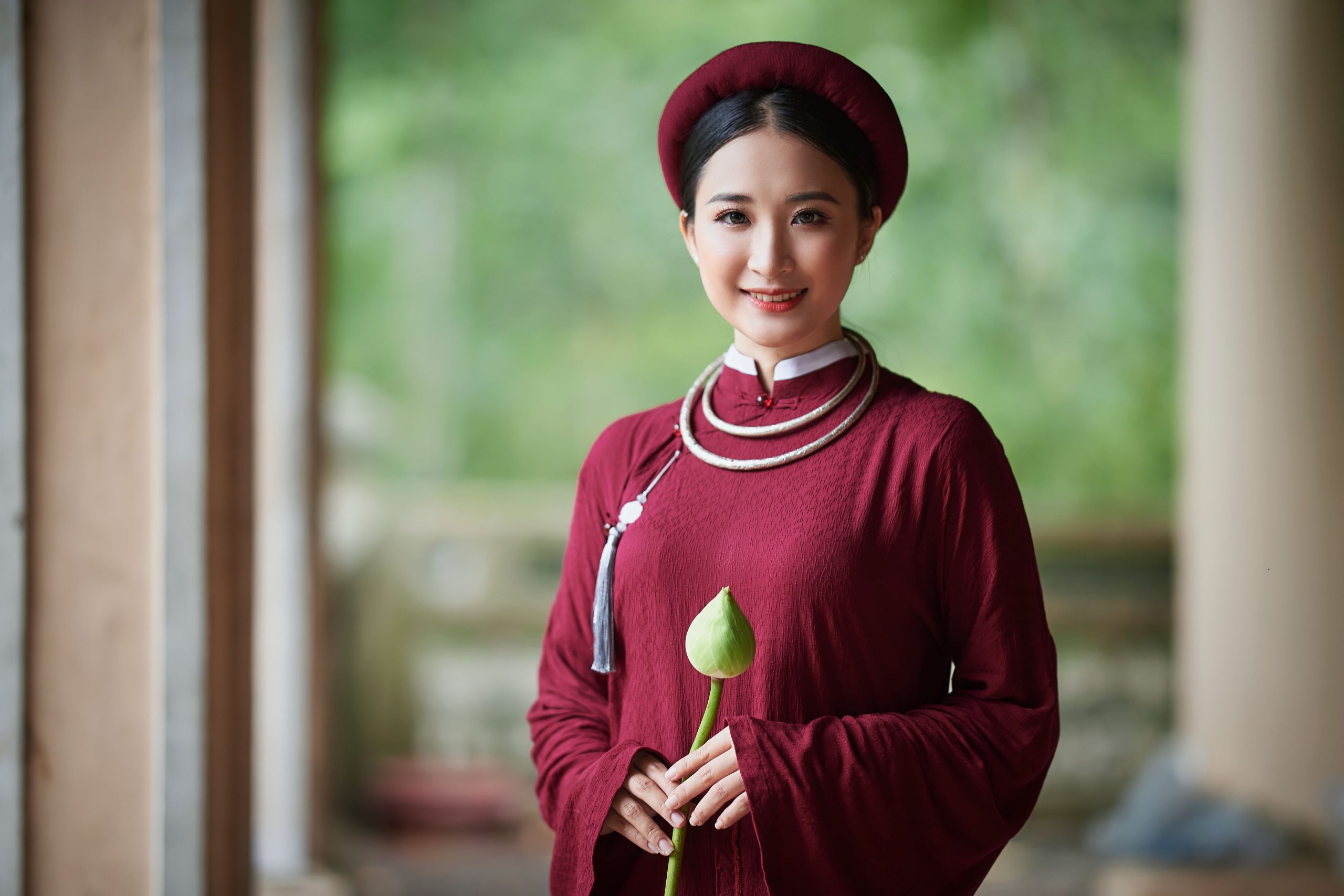 Femme élégante vêtue traditionnellement tenant fleur lotus