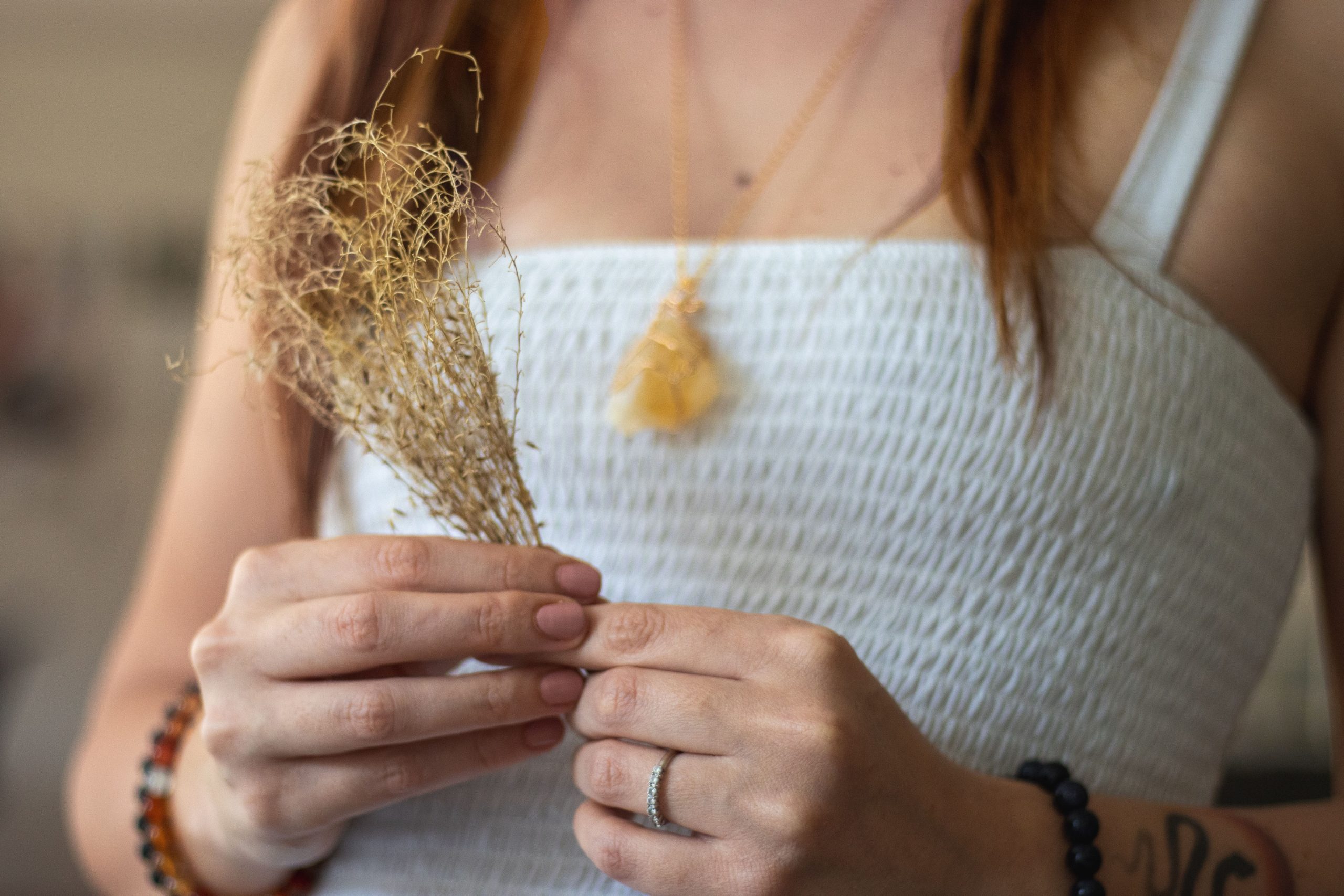 Femme portant bijoux ambre avec plante sèche