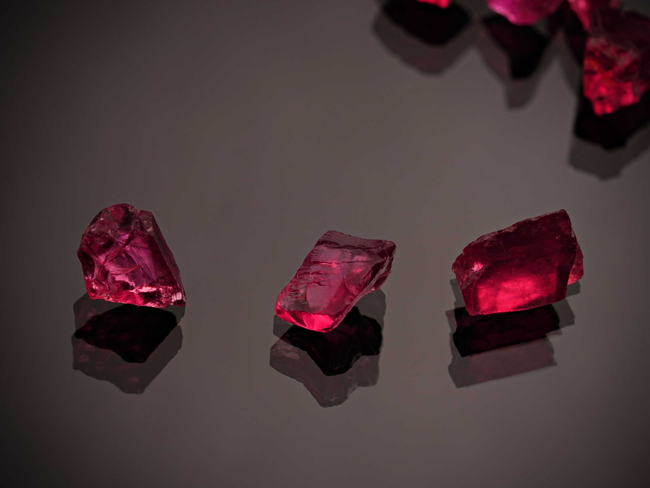 Trois gemmes rouges scintillantes sur fond noir