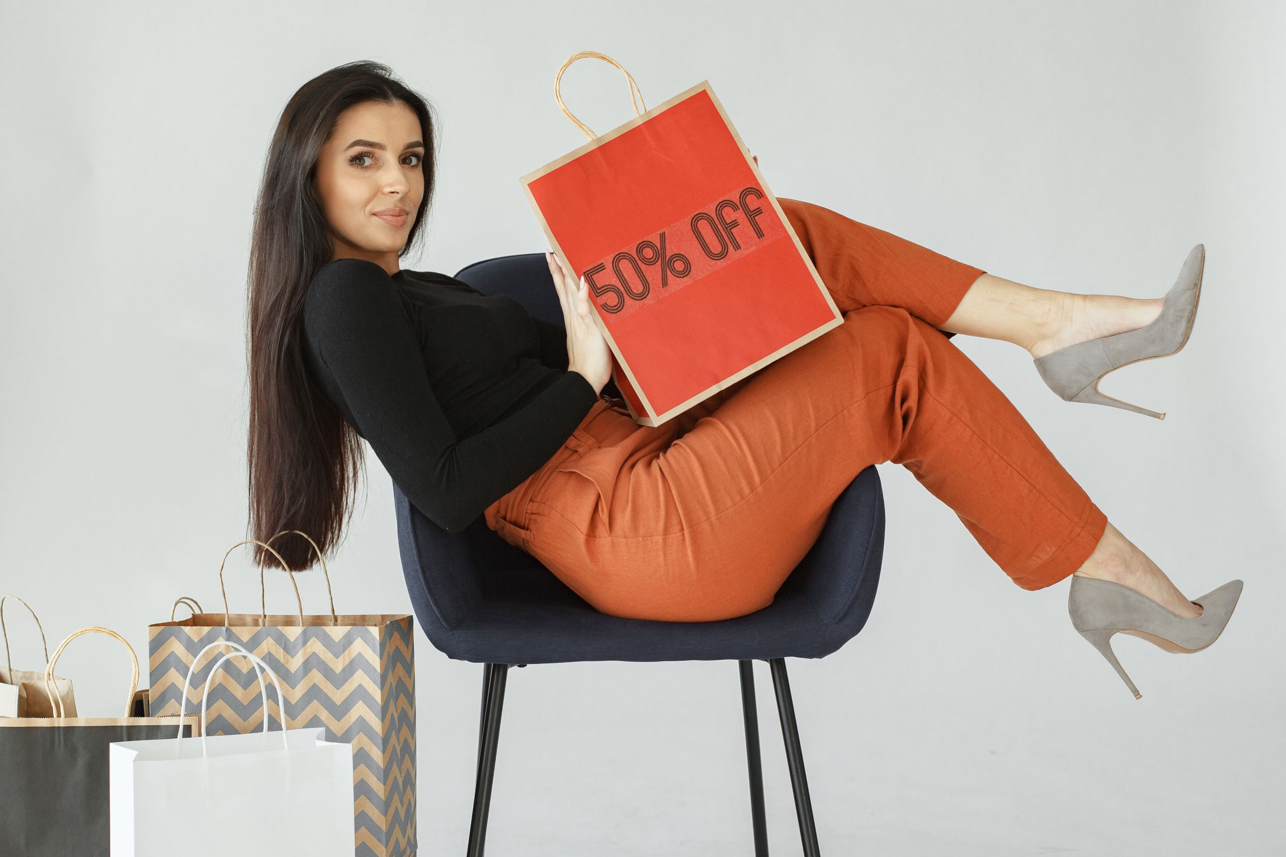 Femme élégante tenant un sac avec étiquette soldes