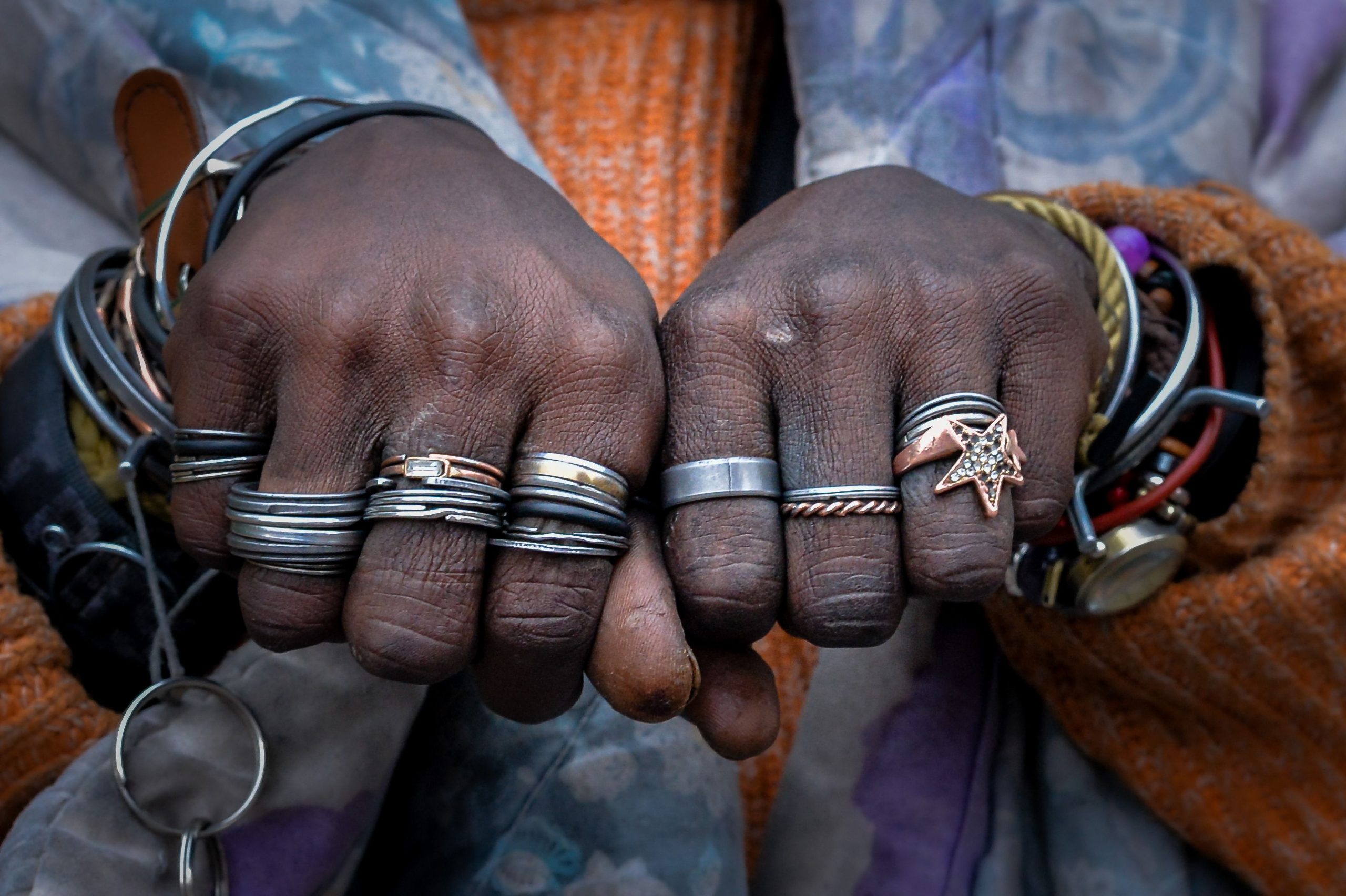 Mains portant plusieurs bagues et bracelets