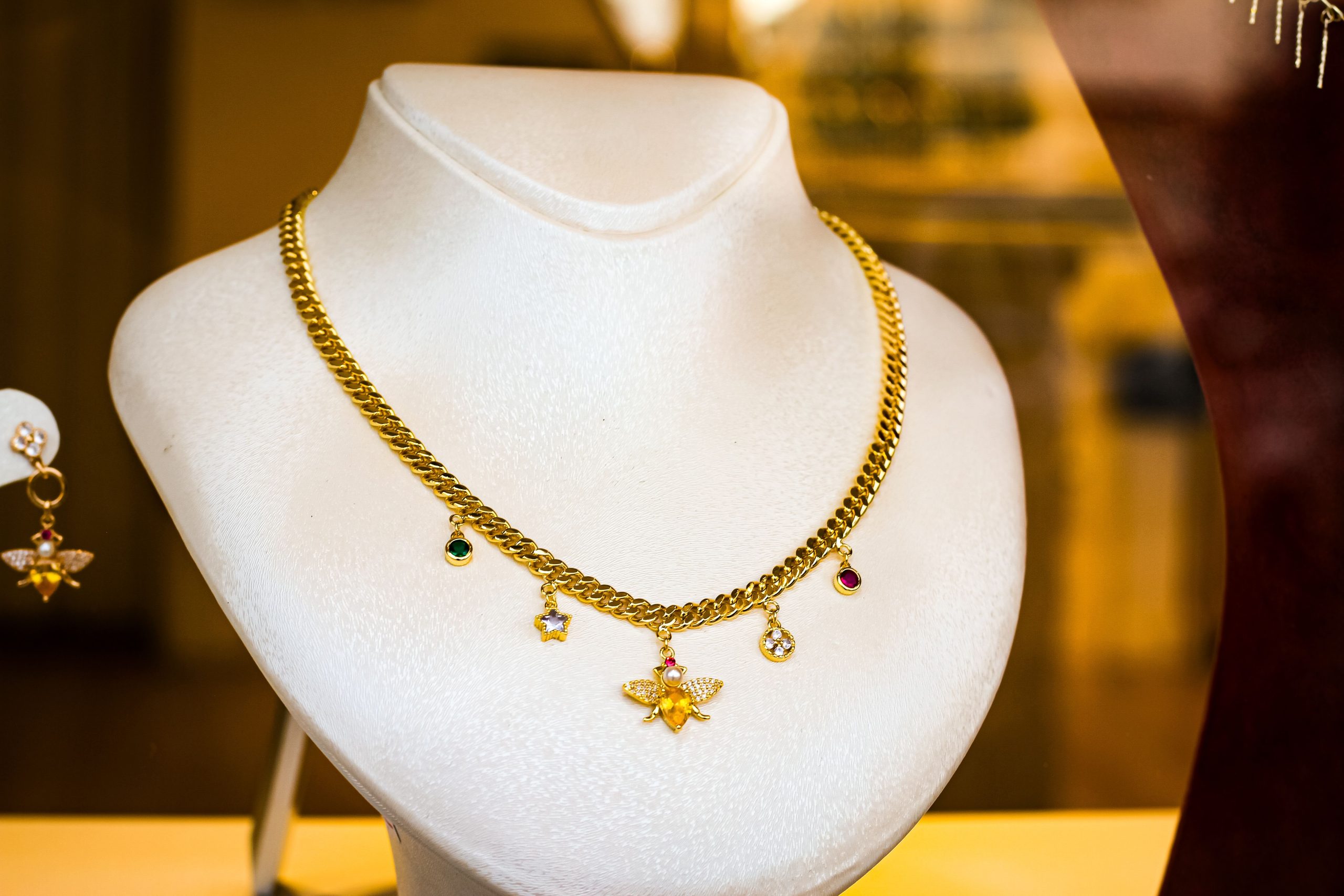 Collier doré avec pendentifs sur buste blanc