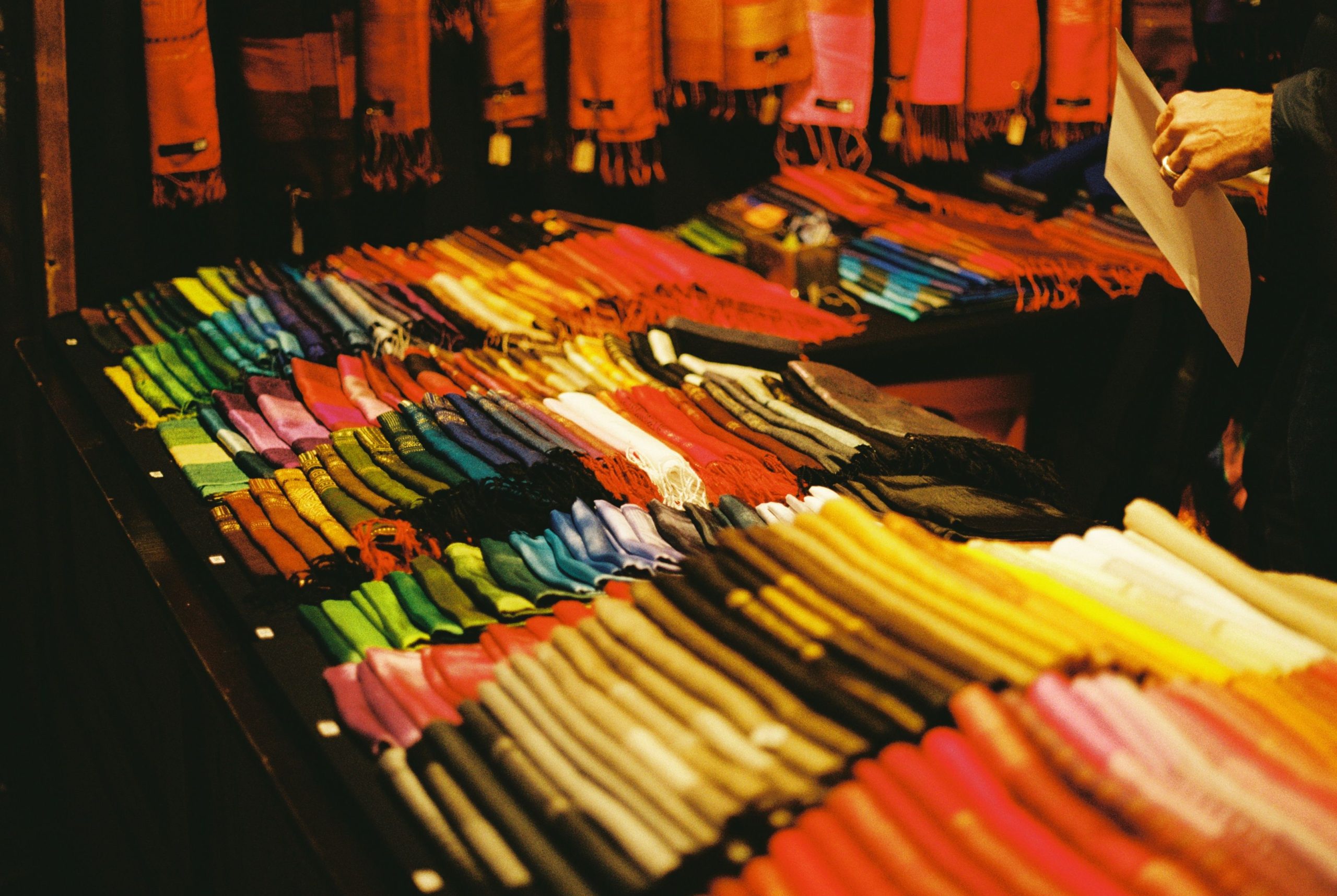 Étal de marché présentant des foulards colorés